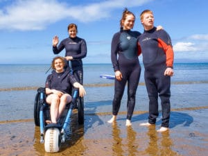 Student and instructors getting photos taken during inclusive surf lesson